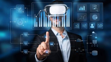 A business professional engages with virtual reality technology while analyzing data and statistics in a modern office setup, showcasing innovation and interaction. Raster
