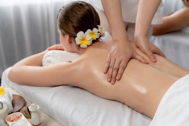 Kafkas çift müşterisi stres önleyici spa masajının keyfini çıkarıyor ve lüks otel veya oteldeki gündüz açık hava ortamında güzellik teniyle eğleniyor. Sessiz.