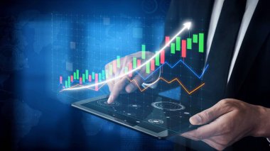 A modern businessman interacts with a tablet displaying vibrant financial graphs and charts, showcasing data analysis in a digital business environment. Copula