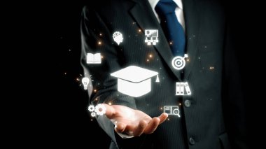 Takım elbiseli bir işadamı, karanlık bir ortamda büyüme, yenilik ve mesleki gelişim fırsatlarını temsil eden çeşitli eğitim ve başarı simgelerini parlak bir şekilde elinde tutuyor. Dörtgen