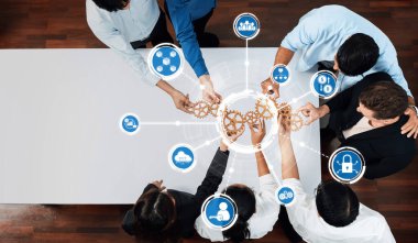 A top-down view of a diverse team engaged in a collaborative business meeting, focusing on innovative ideas and strategies represented by gear icons. Amity