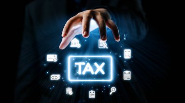 Profesyonel bir iş adamı, dijital vergilendirme ve modern mali yönetim çözümlerini temsil eden finansal sembollerle çevrili parlak bir vergi simgesine uzanır. Dörtgen