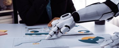 İş veri analizinde işbirliği yapan bir insan ve bir robotu gösteren dinamik bir sahne. Robot, gelecekteki iş yeri teknolojisini somutlaştıran grafiklere ve grafiklere işaret ediyor. Noogenesis