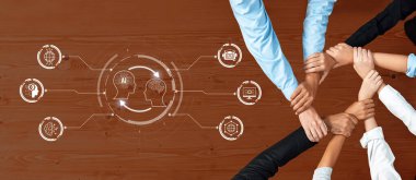 Hands from diverse individuals unite in a modern workspace, symbolizing collaboration and communication enhanced by technology for innovative idea generation. Trope