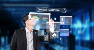 Profesyonel bir adam, veri analizi ve yenilikçi dijital arayüzler yoluyla içerik pazarlama stratejilerini keşfetmek için sanal gerçeklik teknolojisiyle etkileşim içindedir. XDMCP