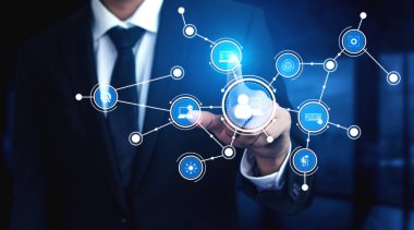 Profesyonel bir işadamı, modern bağlantıyı vurgulayarak, lüks ofis ortamında teknoloji ve iletişimi gösteren bir dizi dijital ağ ikonu kullanır. Tessel