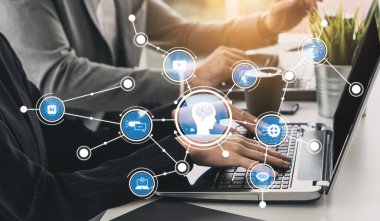 A modern workspace showcasing teamwork and technology integration. Professionals collaborate over a laptop with digital communication symbols, emphasizing productivity and innovation. Tessel