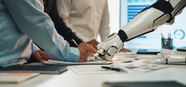 Robot bir elin ofiste insanlara yardımcı olması, profesyonel ortamlarda teknolojinin ve işbirliğinin geleceğini sembolize ediyor. Noogenesis