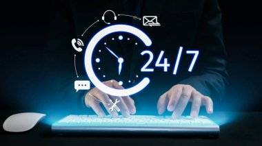 A business professional engages in 24 hour customer service, using a keyboard in a modern setting with icons representing various communication methods and urgency. Qubit