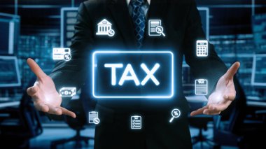 Bir işadamı lüks bir ofiste vergiyle ilgili çeşitli dijital simgeler sergiliyor. Bu resim finansal planlama, analiz ve modern muhasebe hizmetlerini temsil ediyor. Dörtgen