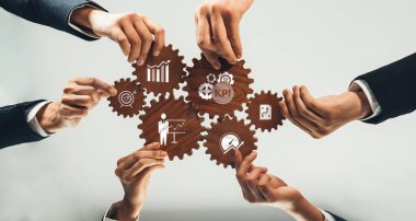 Hands of diverse professionals intertwine to showcase gears, symbolizing teamwork and key performance indicators for effective business strategy and organizational success. Amity