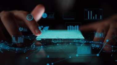 Hands interact with a glowing tablet displaying data visualizations, showcasing the integration of modern technology and business analytics in a dynamic digital environment. Xenic