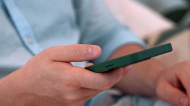 Orta yaşlı bir adam oturma odasındaki koltukta oturur telefon arama verilerini kullanır çocukları iyi bir yetişkin baba ya da eğlence olarak yetiştirir. İşadamı teknolojiyi kolaylık için kullanır. Uyumsuzluk.