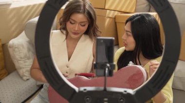 İnternette yayınlanırken gitar kılıfını gösteren ve satan mutlu bir çift. Çekici kız oturma odasında reklam ürünleri için online pazarlama kullanarak yayın yapıyor. Myrmidon.