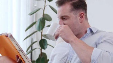 Elinde kahve fincanı olan bir adam, ders kitabı okur, sosyal ve mesleki teknoloji bilgisini arttırır ya da çocukları iyi bir yetişkin olarak yetiştirerek akıllı bir baba olur. Hayat boyu öğrenme konsepti. Uyumsuzluk.