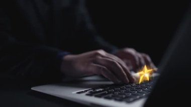 Dizüstü bilgisayar klavyesinde yazı yazan eller, parlayan yıldızlar ve sohbet baloncuklarıyla çevrili, çevrimiçi geri bildirim ve dijital ortamda müşteri reytinglerini sembolize eden çekici bir sahne yaratıyor. Dörtgen