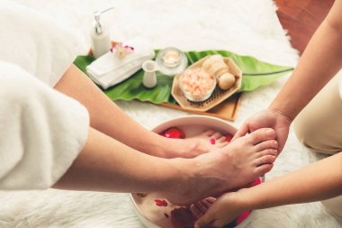 Adam lüks kaplıcalarda mutlu ayak masajına devam ederken, masör de hafif gün ışığı atmosferinde refleksoloji terapisi ya da otel ayak spa 'sında. Sessiz.