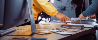 Modern bir ofis masasında teknoloji ve proje materyalleri ile fikirleri tartışan ve paylaşan, yaratıcılık ve takım çalışmasını vurgulayan işbirlikçi bir çalışma alanı tasarımcısı. SACTR