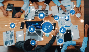 A vibrant and engaging business meeting scene demonstrating teamwork and innovation, featuring data analysis, brainstorming, and strategic planning around a table in a modern office setting. Amity