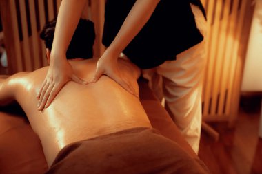 Beyaz erkek müşteri stres önleyici spa masajının keyfini çıkarıyor ve lüks otel ya da oteldeki ortam kaplıcalarında sıcak mum ışığında güzellik teniyle eğleniyor. Sessiz.