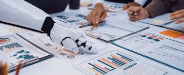 Bir robot el, verimli bir toplantı sırasında çizelge ve grafikleri analiz eden bir iş ekibiyle birlikte çalışır ve teknolojinin iş yerinde bütünleşmesini vurgular. Noogenesis