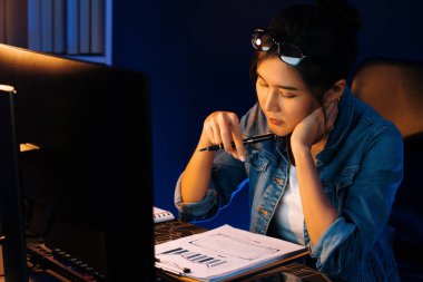 Genç ve güzel Asyalı iş kadını evrak işleri ile ilgili pazar raporunu analiz ediyor, iş planını düşünüyor ve gece vakti neon ışıklı ofiste yeni bir strateji projesi yaratıyor. Taktik.