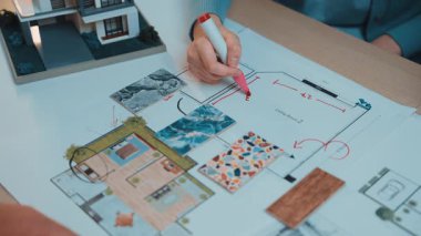 A vibrant scene of professionals analyzing a detailed floor plan for a modern home design, showcasing creativity and collaboration in a stylish workspace. SACTR