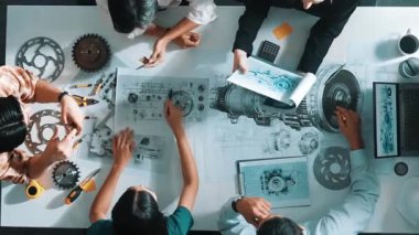 Türbin motoru tasarlamak için çalışan akıllı mühendis takımının yukarıdan aşağıya hava görüntüsü. Profesyonel teknisyen jet motoru yapımını tartışırken motorun bir kısmını işaret ediyor. Hizalama.