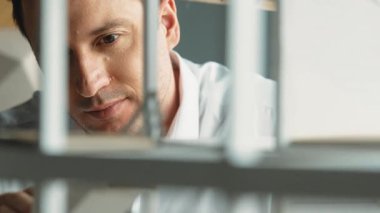 Kafkasyalı mimar mühendisinin yakın çekimi ev inşaatını denetlemek ve bina malzemelerini kontrol etmek. Proje yöneticisi modele dikkatlice bakarken kalemi işaret ediyor. Yönlendirici.