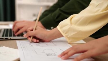 Mimari ve güvenlik mühendisi, modern ofiste doğruluk için mimari belge ve ölçüm aracına dizüstü bilgisayardaki inşaat ayrıntılı planlarını yazar. - Yakın çekim. Tanımlama.