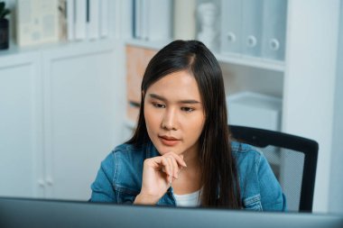 Genç ve güzel Asyalı yaratıcı yönetici bilgisayar üzerinde çalışıyor, yeni bir web sitesi tasarımı ile yeni sosyal medya çevrimiçi kanal planlaması üzerinde modern ev ofisinde kot pantolon gömleği ile çalışıyor. Taktik.