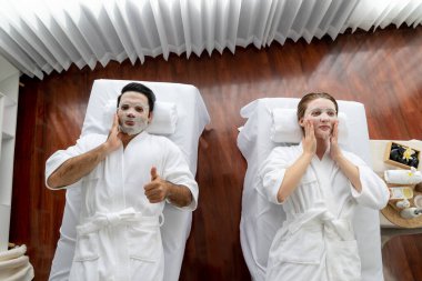 Kaplıca salonunun sakin, modern gündüz atmosferi, birkaç müşteri yüz maskesi takarak kendini yenilemeye çalışıyor. Yüz bakımı ve güzellik kozmetolojisi prosedürü. Sessiz.