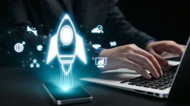 This image depicts a modern technology concept showcasing a rocket launching from a smartphone alongside business graphics and data analysis on a laptop, symbolizing innovation. Qubit