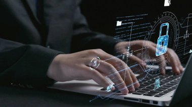 A close-up view of hands typing on a laptop surrounded by a digital lock graphic, emphasizing the importance of cybersecurity and data protection in today technology landscape. Qubit