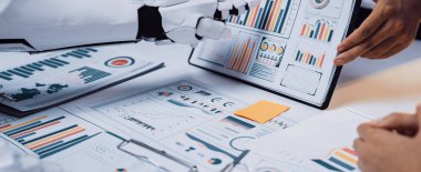 Bir insan ve bir robot çeşitli grafik ve grafiklerle çevrili veri analizinde işbirliği yapıyorlar. Modern teknolojilerin iş karar verme süreçlerindeki rolünü vurgulamak. Noogenesis