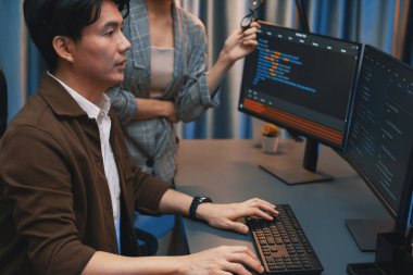 Bilgi teknolojisi geliştiricileri modern ofisteki neon ışık odasında verileri çevrimiçi olarak çalıştıran akıllı web sitesi geliştirme kodlayıcı sistemine işaret ediyorlar. İnfobahn.