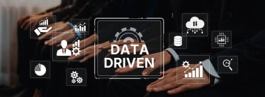 A group of business professionals focused on implementing data-driven strategies with visual representations of analytics and technology in a corporate setting. Trope