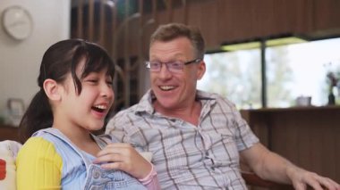 Büyükbaba ve torun birlikte TV 'de ilginç bir eğlence medyası izliyorlar. Eski üst düzey kullanım teknolojisi, genç nesil çapraz nesil ile iletişim kurarak aile bağlarını güçlendiriyor. Uyumsuzluk.